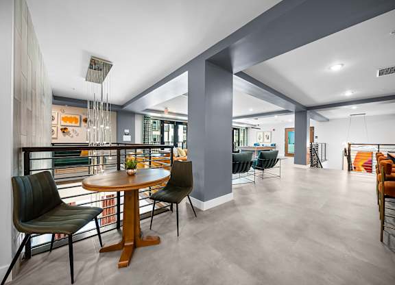 A modern dining room with a round wooden table and chairs.