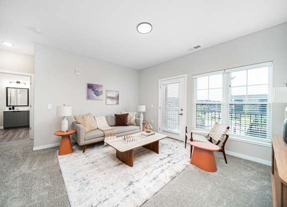 A living room with a grey couch, a coffee table, and a rug.