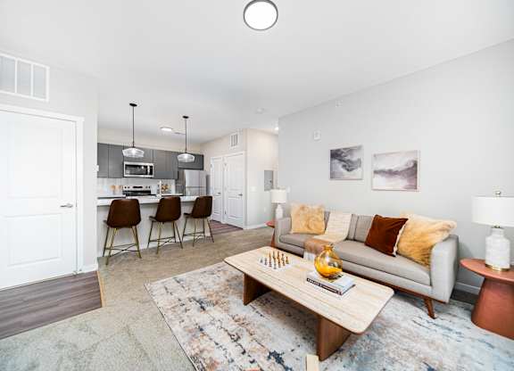 A living room with a grey couch and a wooden coffee table.