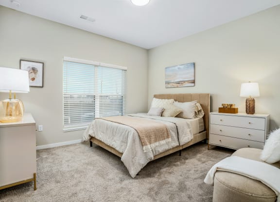a bedroom with a bed and a dresser and a window
