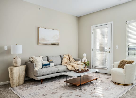 a living room with a couch and chairs and a coffee table