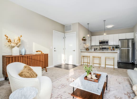 a living room with a couch and a coffee table in front of a kitchen