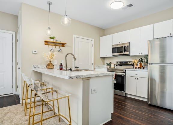 a kitchen with stainless steel appliances and a marble counter top