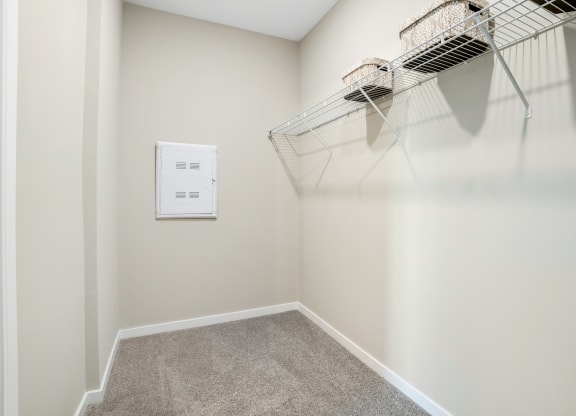 an empty closet with a wire basket hanging on the wall