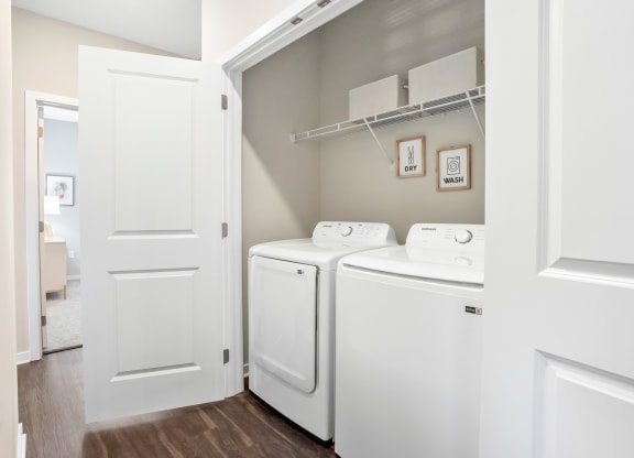 a spacious laundry room with washer and dryer and a door to the bathroom