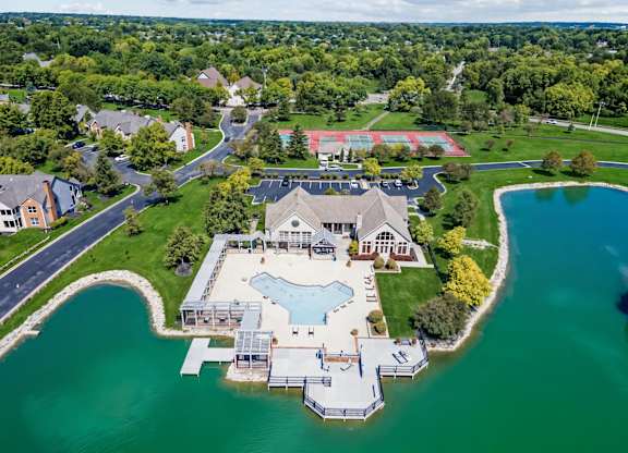 A large house with a pool is surrounded by water.