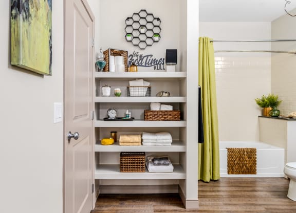 a bathroom with shelves and a shower and a yellow curtain