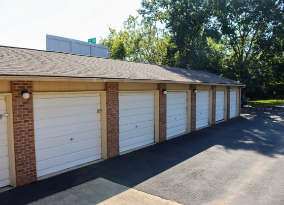 a row of white garage doors on a brick building
