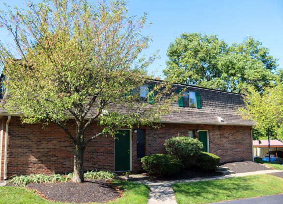 a brick house with a tree in front of it