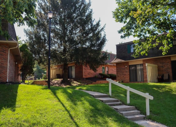 a house with a white fence and stairs in front of it