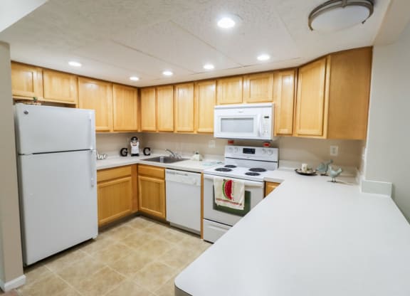 a kitchen with white appliances and wooden cabinets