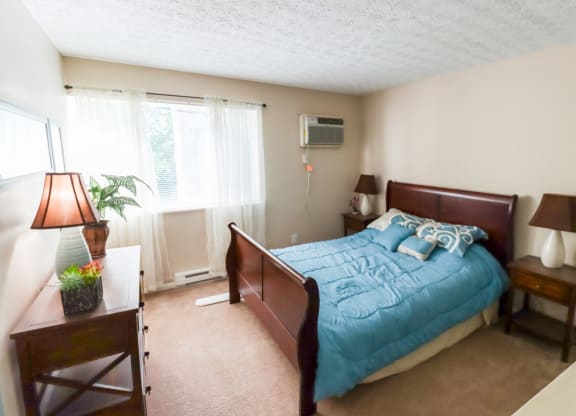 a bedroom with a bed and a dresser and a window