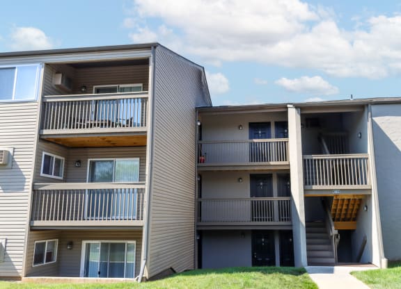 a view of two apartment buildings with balconies and a lawn