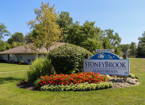 the sign for stoneybrook in front of a garden with colorful flowers