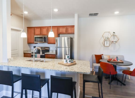 a kitchen and dining area with a granite counter top and stainless steel appliances