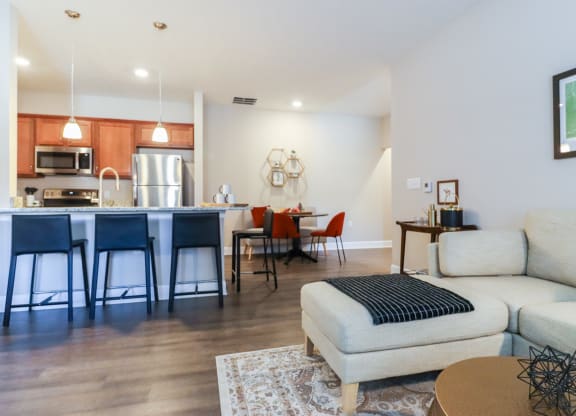 a living room with a couch and a kitchen with a table and chairs