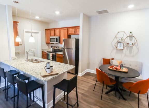 a kitchen and dining area with a granite counter top and stainless steel appliances