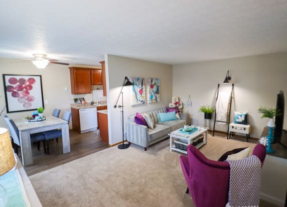 A living room with a purple chair and a white couch.