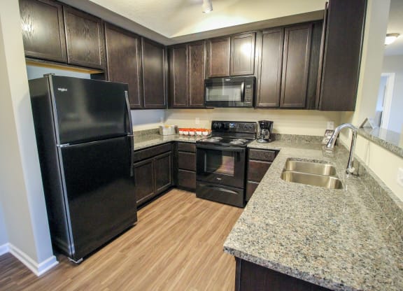 a kitchen with black appliances and a granite counter top