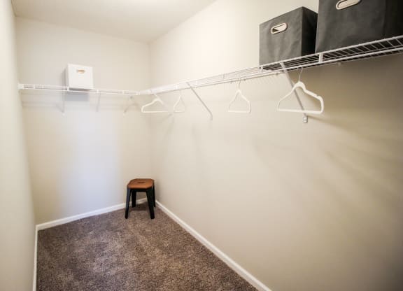 a walk in closet with a small stool in a 555 waverly unit