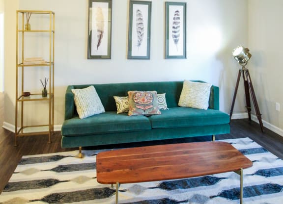 a living room with a green couch and a ceiling fan
