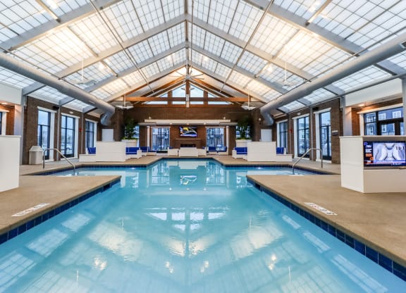 a large indoor swimming pool with a glass ceiling and skylights