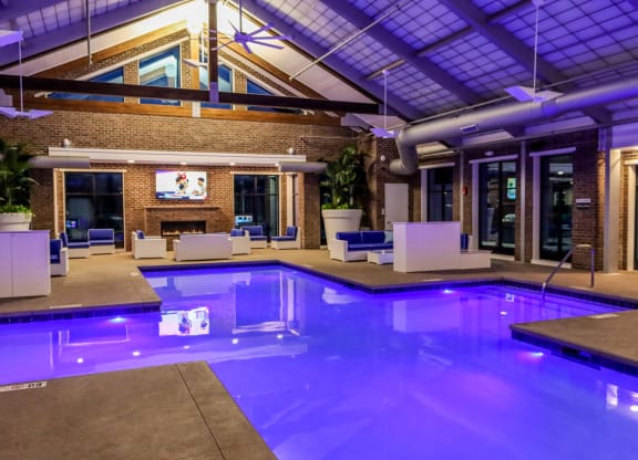a large indoor pool with lounge chairs and a fireplace