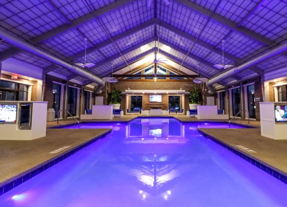 a large indoor swimming pool with a glass ceiling