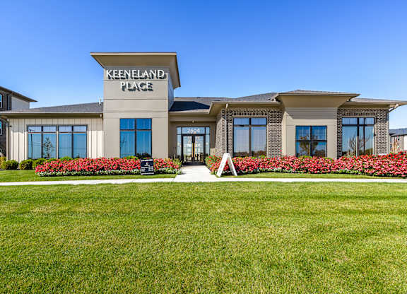 The Keeneland Place sign is on a building with a lawn in front.
