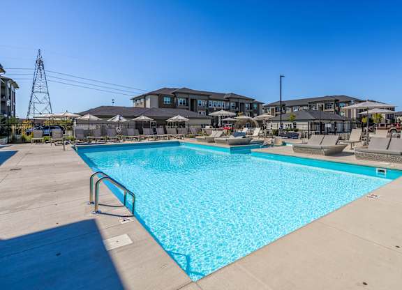 A large swimming pool in a sunny outdoor setting.