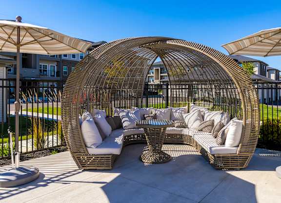 A large wicker outdoor furniture set is on a patio.