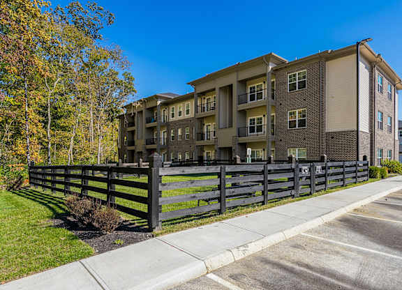 A modern apartment building with a black fence in front.