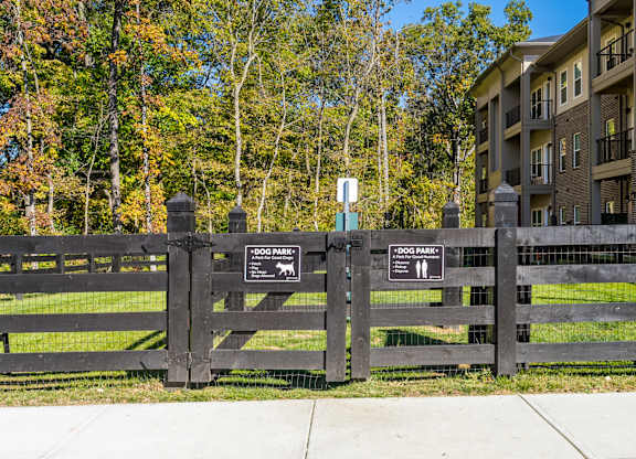 A black fence with two signs that say