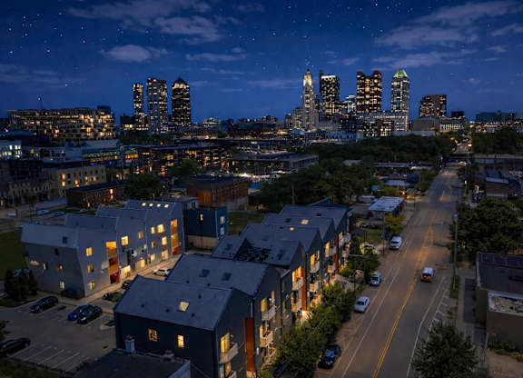 A cityscape at night with a road running through it.