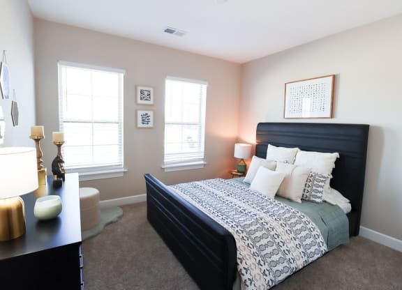 a bedroom with a bed and two windows