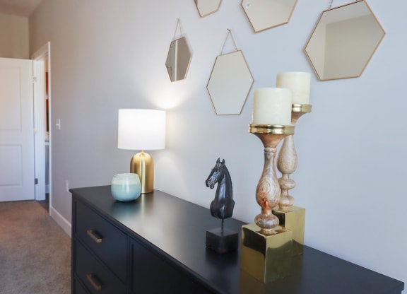 a black dresser with lamps and a horse statue on it