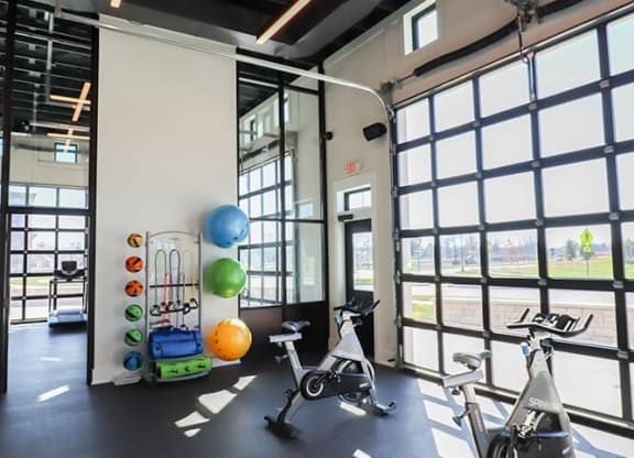 a workout room with exercise bikes and windows