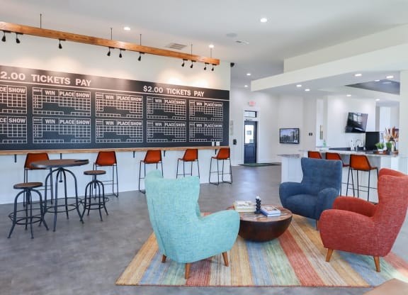 a lobby with chairs and a bar and a large chalkboard