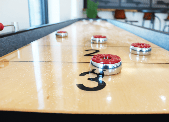 a shuffleboard court with red and white balls on it