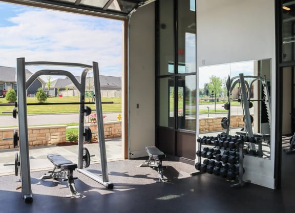 a gym with weights and a window in a building