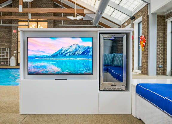 a television on a stand in front of a pool
