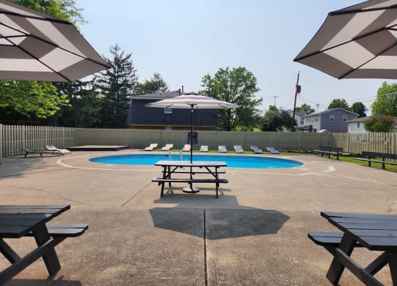 our community has a pool and picnic tables with umbrellas