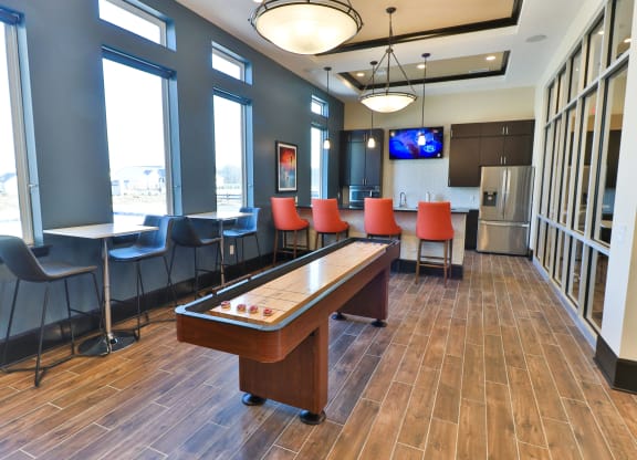 a game room with a pool table and chairs