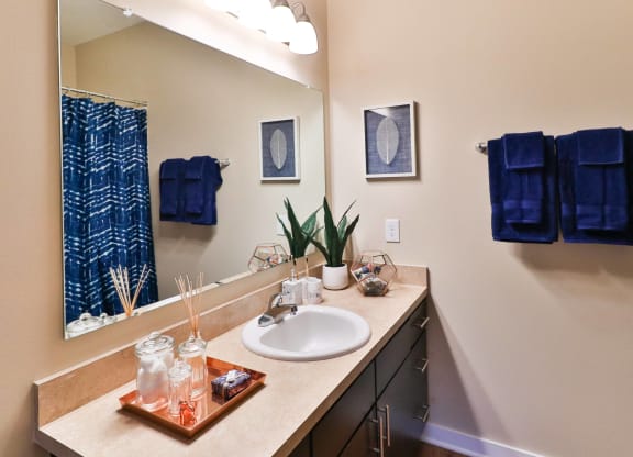 a bathroom with a sink and a mirror and blue towels