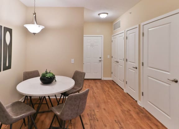 a dining room with a table and chairs and a hallway with white doors