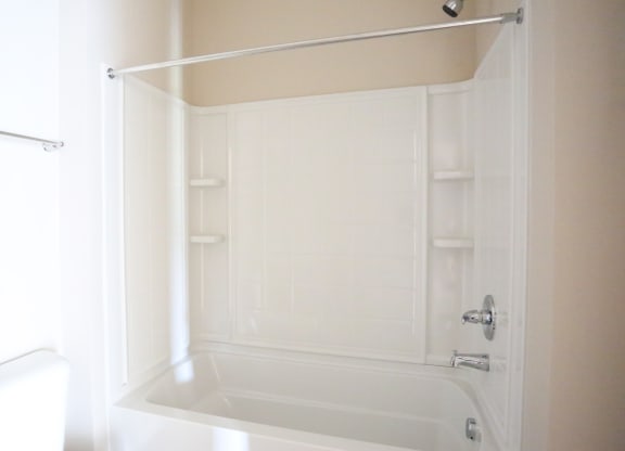 a white bathroom with a shower and a toilet