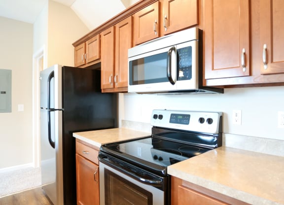 a kitchen with wood cabinets and black appliances and a black refrigerator
