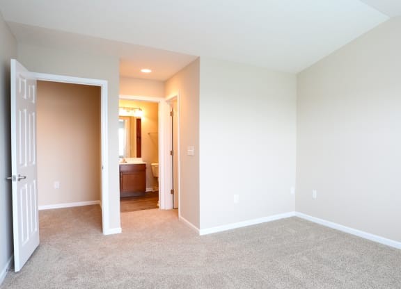 a room with carpet and a door to a bathroom