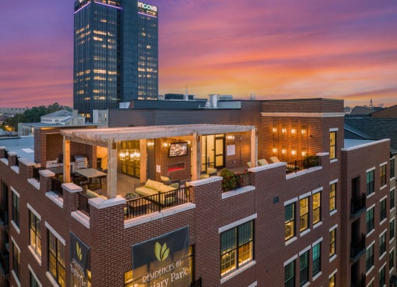 a large brick building with a roof terrace and a patio