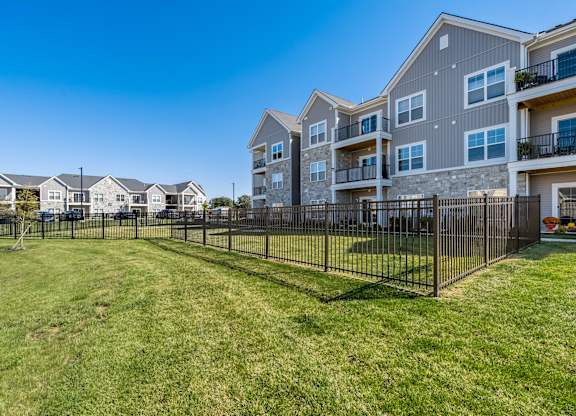 A row of houses with a black fence in front of them.